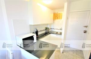 Una cocina con gabinetes blancos y encimera. en 426 Estudio en Minerva Apartamentos - Vista al jardín - Piscina y Playa, en Benalmádena