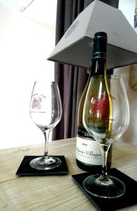 een fles wijn en twee glazen op een tafel bij Les Vacances in Passy