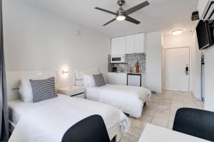a bedroom with two beds and a ceiling fan at Best location in MB - 2 min to beach & Ocean Dr in Miami Beach