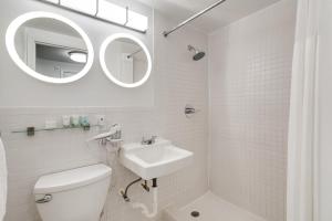 a bathroom with a sink and a toilet and a mirror at Best location in MB - 2 min to beach & Ocean Dr in Miami Beach