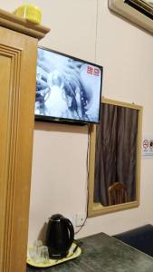 TV colgada en la pared de una habitación en SUSAN HOTEL SEAFRONT, en Sandakan