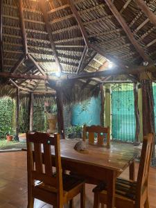 Mauras Tropical Mini Hostel & Tours في باكيرا: طاولة خشبية مع كرسيين وسقف خشبي