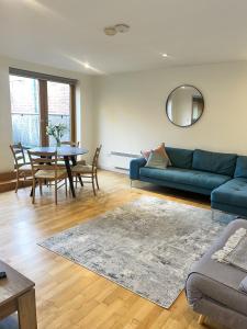 a living room with a blue couch and a table at Spacious Mews Apartment, Clapham in London