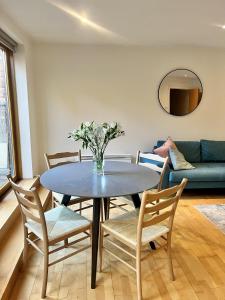 a dining room table with a vase of flowers on it at Spacious Mews Apartment, Clapham in London