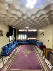 - un salon avec des canapés bleus et un grand tapis dans l'établissement Villa familys, à Fès