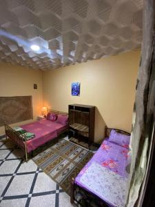 a room with two beds and a ceiling at Villa familys in Fez