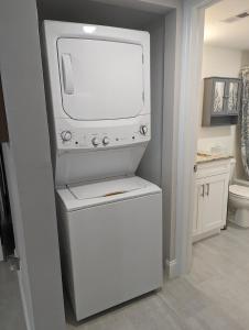 a bathroom with a tv on top of a machine at NEW condo! Just 15 min to Ft Myers and Sanibel beach! Great Location!! in Fort Myers