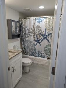 a bathroom with a shower curtain and a toilet at NEW condo! Just 15 min to Ft Myers and Sanibel beach! Great Location!! in Fort Myers