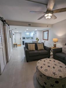 a living room with two couches and a table at NEW condo! Just 15 min to Ft Myers and Sanibel beach! Great Location!! in Fort Myers