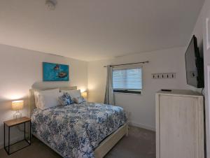 a bedroom with a bed and a television in it at NEW condo! Just 15 min to Ft Myers and Sanibel beach! Great Location!! in Fort Myers