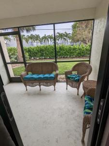 a screened in porch with two chairs and a couch at NEW condo! Just 15 min to Ft Myers and Sanibel beach! Great Location!! in Fort Myers