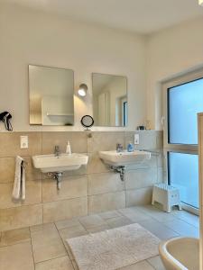 Baño con 2 lavabos y espejo en Ferienhaus Oldenburg, en Oldenburg