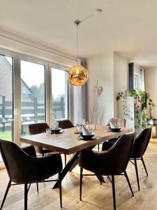 una sala da pranzo con un grande tavolo in legno e sedie di Ferienhaus Oldenburg a Oldenburg