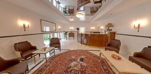 a large living room with chairs and a rug at Hotel "Friedrich-Franz-Palais" in Bad Doberan