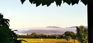 a view of a field with mountains in the distance at Annahouse in Chiang Rai