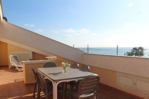 uma mesa e cadeiras numa varanda com vista para o oceano em Il Borgo della Marinella Case Vacanze em Amantea