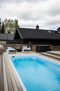 a large blue swimming pool next to a house at Villa Marikollen in Hektner