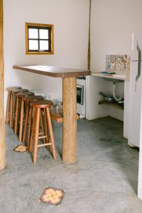 a table and stools in a kitchen with a counter at Recanto Sole Luna in Maresias