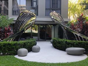 two metal sculptures in a garden in front of a building at The Marvest Hua Hin in Hua Hin