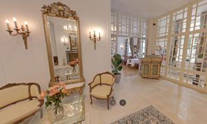 バート・ドーベランにあるHotel "Friedrich-Franz-Palais"の鏡、椅子、テーブルが備わる客室です。