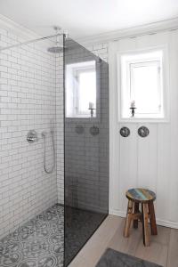 a bathroom with a glass shower with a stool at Villa Marikollen in Hektner