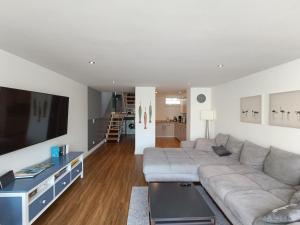 a living room with a couch and a flat screen tv at Beachhouse mit privater Sauna und Kamin, 700m zum Strand in Schönberger Strand