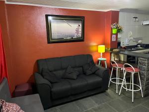 Il comprend un salon avec un canapé et une cuisine. dans l'établissement Anjos Dourados Apartment, à Mangaratiba