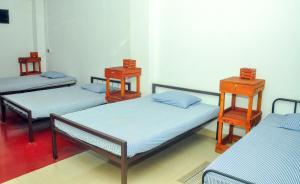 un gruppo di 3 posti letto in una camera di Airport Tourist Resort a Katunayake