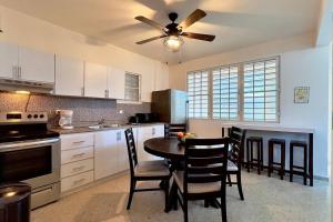 a kitchen with a table and chairs and a ceiling fan at Family & Friends - Beach, BBQ, Private Pool & Pet in Vega Baja