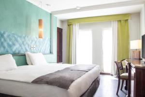 1 dormitorio con cama, escritorio y ventana en Hotel Fundador, en Santiago