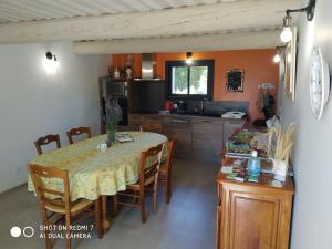 une cuisine et une salle à manger avec une table et des chaises dans l'établissement Le Mas des Calus Chambres d'hôtes, à LʼIsle-sur-la-Sorgue