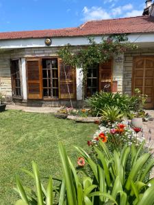 a garden in front of a house with flowers at Soul Habitaciones in Ezeiza +7 photos