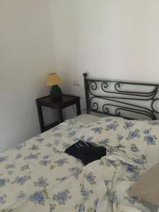 a bedroom with a bed with blue flowers on it at Villa la Ficuzza in Cittadella del Capo