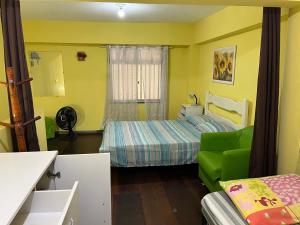 - une chambre avec un lit et un canapé vert dans l'établissement Anjos Dourados Apartment, à Mangaratiba
