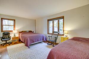 1 dormitorio con 2 camas, 1 silla y 2 ventanas en Lakefront Park Rapids Cabin with Grill and Fire Pit! en Park Rapids