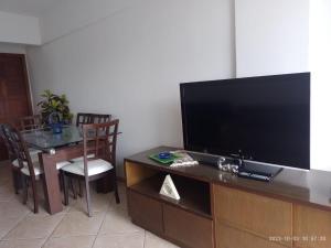 a living room with a flat screen tv and a table at PRIME Beach e Praia do Forte a Pé e Polo Gourmet com carro no estacionamento. in Cabo Frio