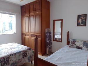 a bedroom with a bed and a wooden cabinet at PRIME Beach e Praia do Forte a Pé e Polo Gourmet com carro no estacionamento. in Cabo Frio +12 photos