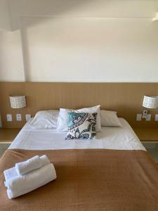 a bed with two towels on top of it at Pipas Ocean by Pipa Centro in Pipa +109 photos