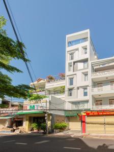 a tall white building on the side of a street at Khang's House in Nha Trang
