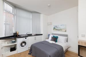 a bedroom with a bed and a washing machine at No 1 Thornhill House in Hartlepool
