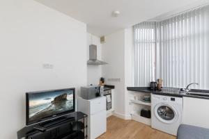 a living room with a tv and a washing machine at No 1 Thornhill House in Hartlepool