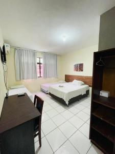 福塔萊薩的住宿－Netuno Beach Hotel，一间卧室配有一张床、一张桌子和一张书桌