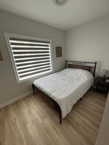 sypialnia z łóżkiem i dużym oknem w obiekcie Brand New Home in Hamilton w mieście Hamilton