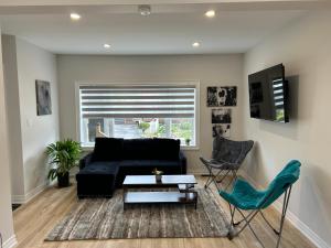 salon z czarną kanapą, stołem i krzesłami w obiekcie Brand New Home in Hamilton w mieście Hamilton
