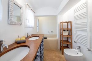 een badkamer met 2 wastafels en een toilet bij Trullo Cristiana in Latiano