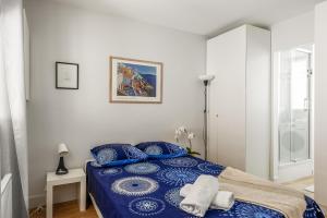 sypialnia z niebieskim łóżkiem i lustrem w obiekcie 1 bedroomed Apartment Repos w Paryżu