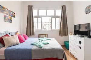1 dormitorio con 1 cama grande y TV en Apartamento Copacabana, en Río de Janeiro