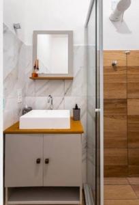 y baño con lavabo, espejo y ducha. en Apartamento Copacabana, en Río de Janeiro