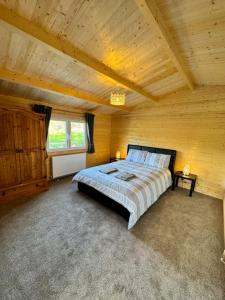 a bedroom with a large bed in a wooden ceiling at Glenariff Forest Pine Cabin in Glenariff