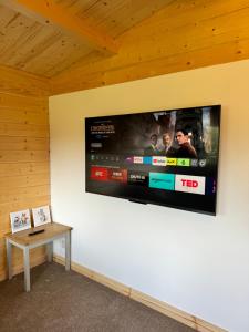 a flat screen tv on a wall in a room at Glenariff Forest Pine Cabin in Glenariff